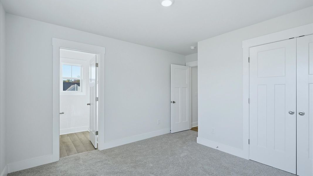 Elegant bedroom retreat featuring soft carpeting and a thoughtfully designed walk-in closet by DRB Homes
