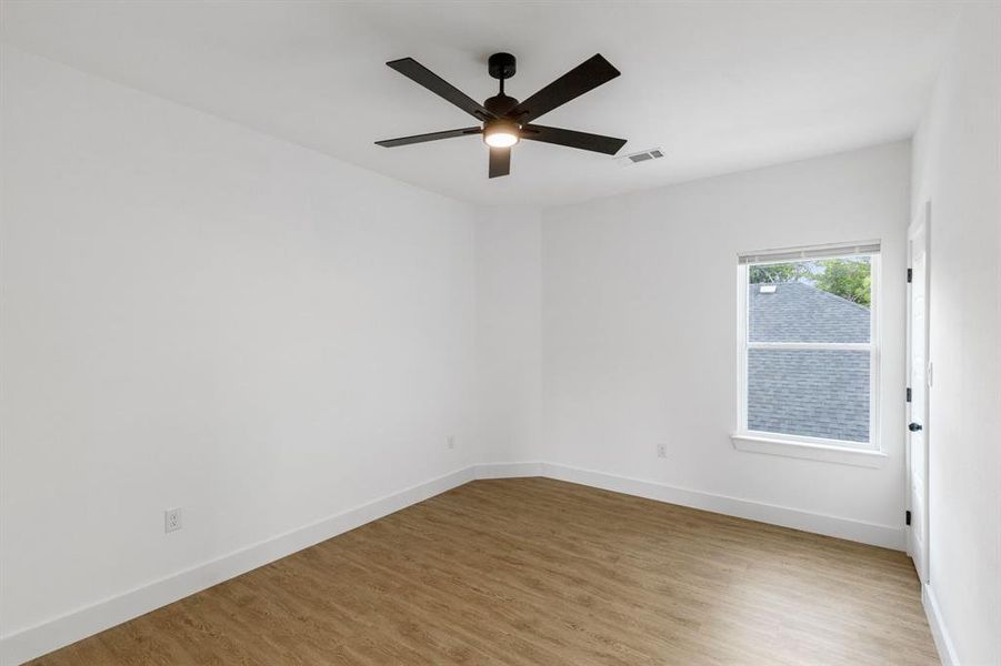 Unfurnished room with light wood-type flooring and ceiling fan