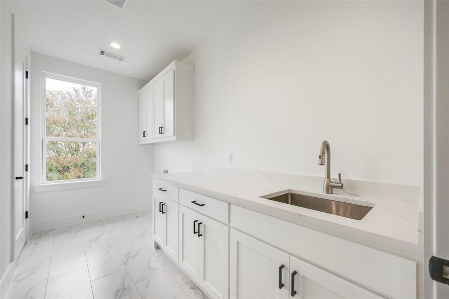 Laundry area with cabinet space, light marble finish flooring, recessed lighting, and hookup for a washing machine Laundry area with cabinet space, light marble finish flooring, recessed lighting, and hookup for a washing machine