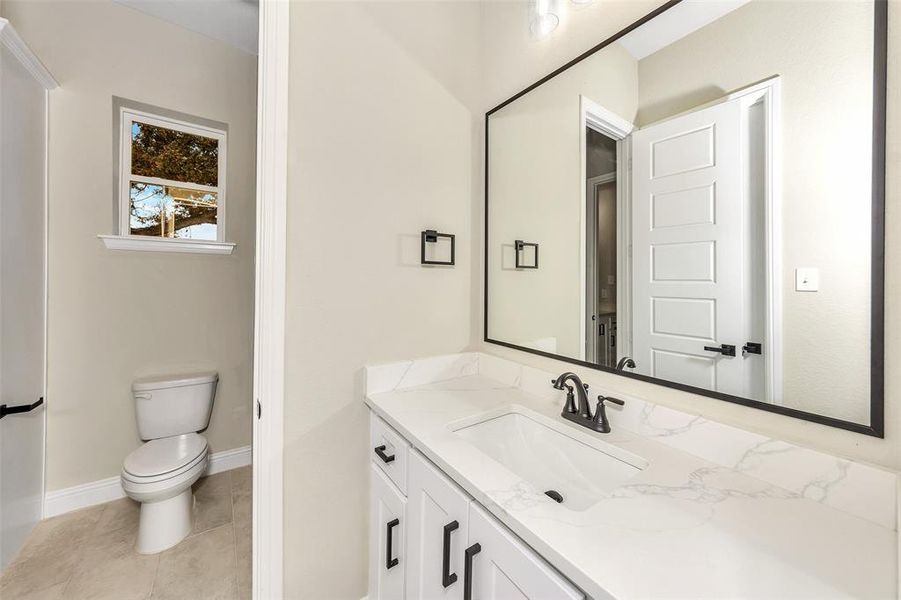 Bathroom featuring tile patterned flooring, vanity, and toilet