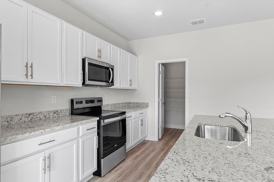 A kitchen with white cabinets.