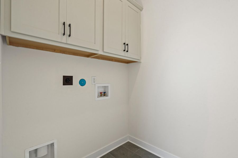 Laundry area with hookup for a washing machine, electric dryer hookup, and cabinet space