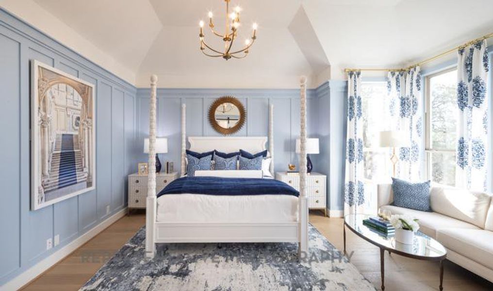 Bedroom featuring a chandelier, lofted ceiling, a decorative wall, and wood finished floors Bedroom featuring a chandelier, lofted ceiling, a decorative wall, and wood finished floors