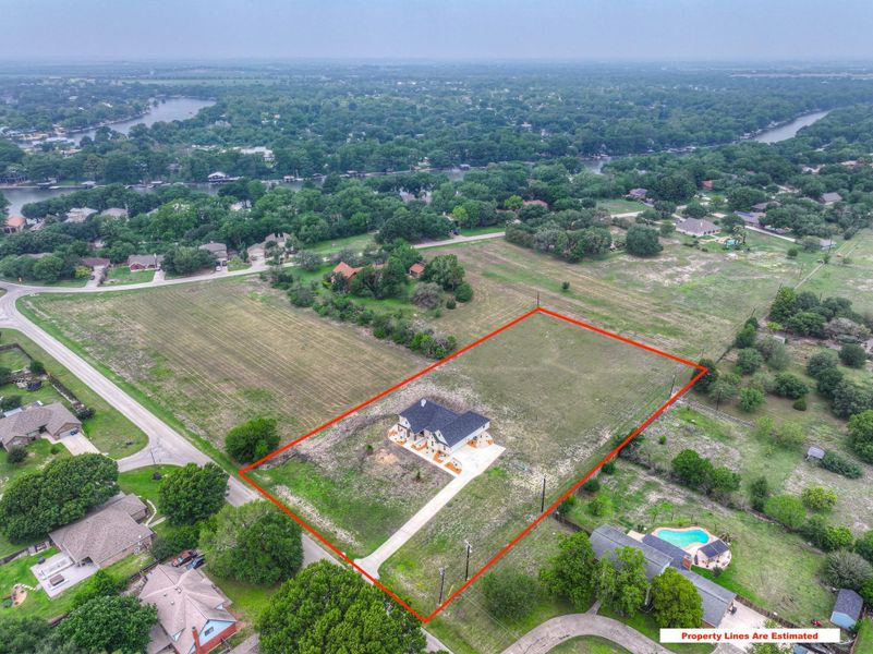 Expansive lot featuring a single-story residence with a dark roof and light exterior, surrounded by undeveloped land. On 2.33 acres.