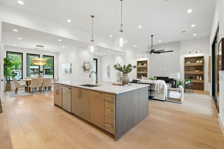 Kitchen featuring modern cabinets, decorative light fixtures, light wood-type flooring, light stone counters, and ceiling fan Kitchen featuring modern cabinets, decorative light fixtures, light wood-type flooring, light stone counters, and ceiling fan