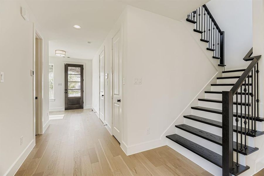 Foyer entrance with wood finished floors, stairs, and recessed lighting