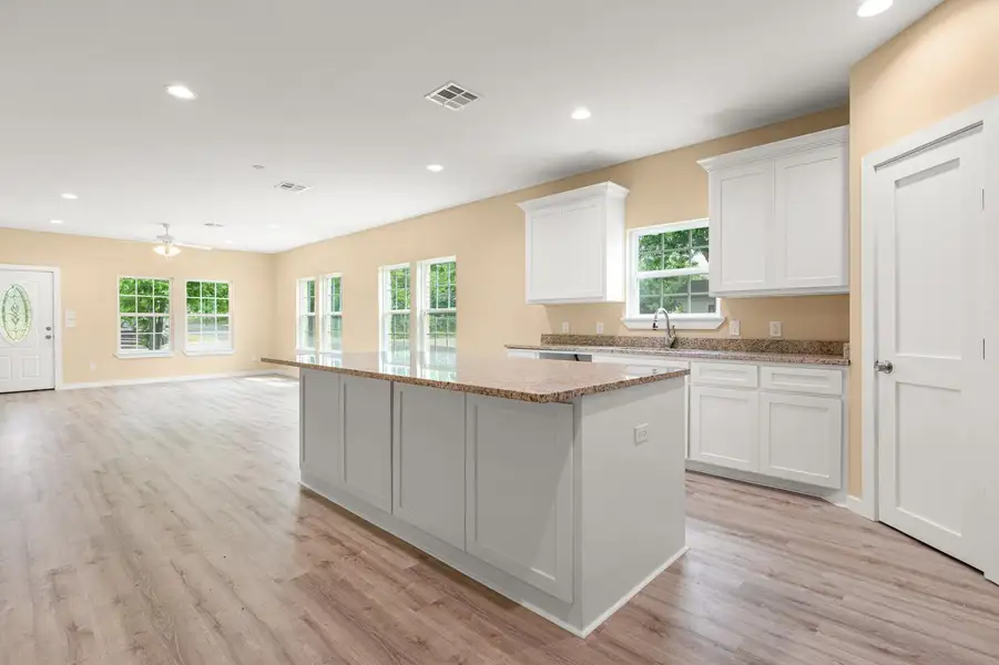 Kitchen featuring a kitchen island, white cabinetry, plenty of natural light, light wood-type flooring, and recessed lighting