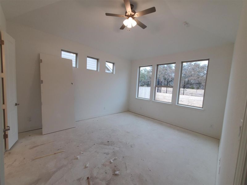 Spare room featuring lofted ceiling and ceiling fan