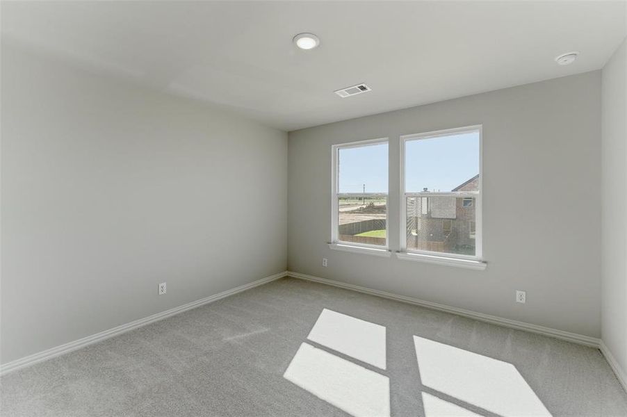 Empty room with light colored carpet and baseboards
