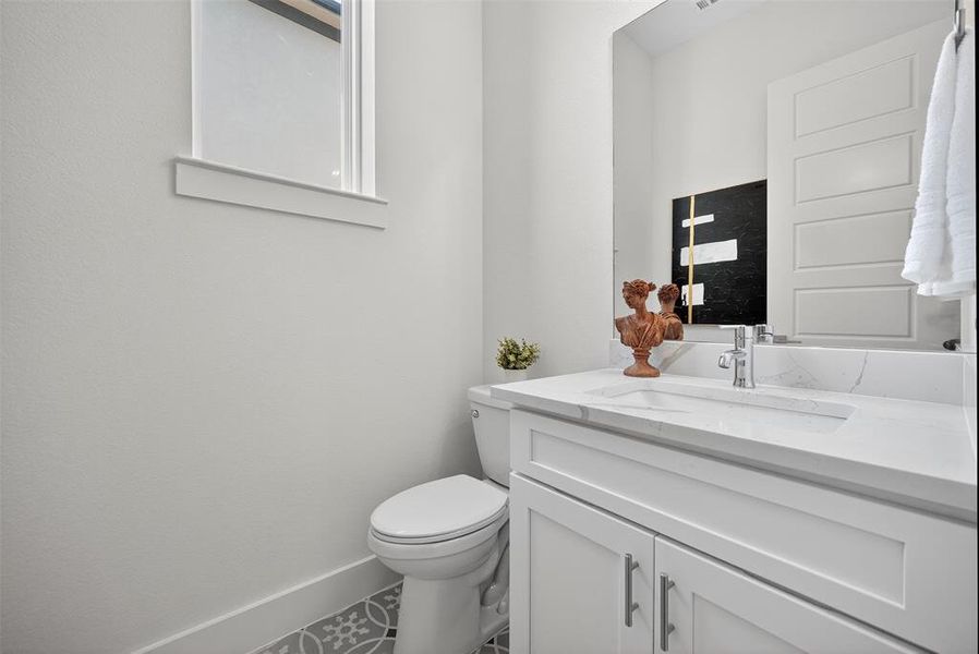 Half bathroom with vanity and baseboards