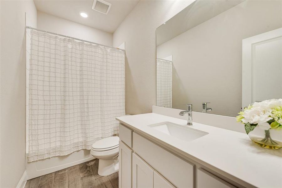 Full bathroom featuring shower / bath combo, vanity, and light wood-style flooring