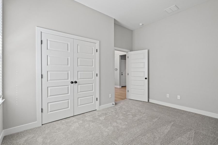 Unfurnished bedroom featuring carpet and a closet