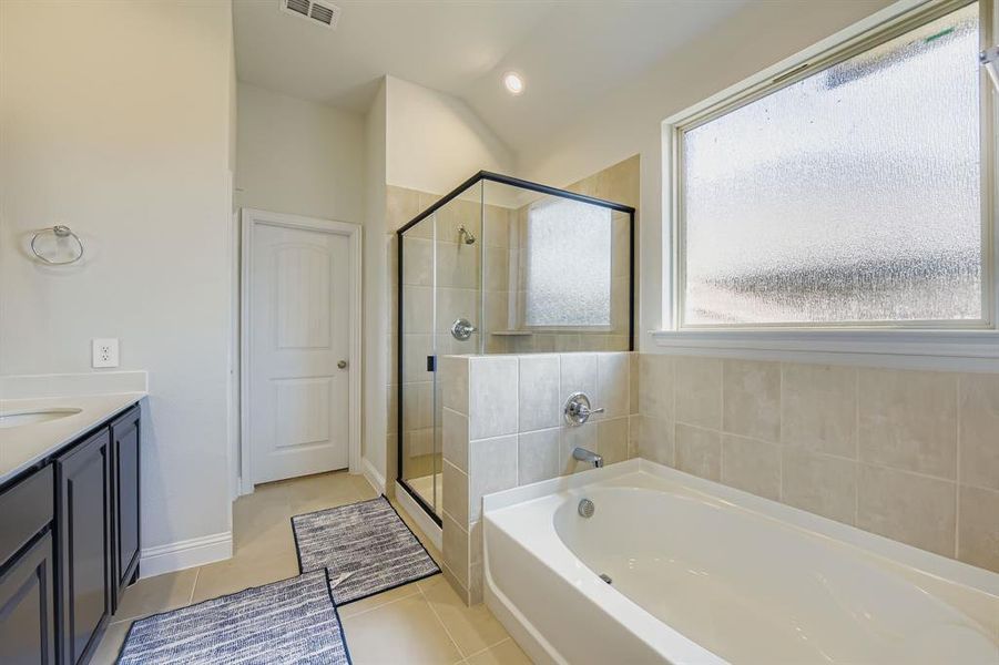 Bathroom with a garden tub, a shower stall, vanity, light tile patterned floors, and recessed lighting