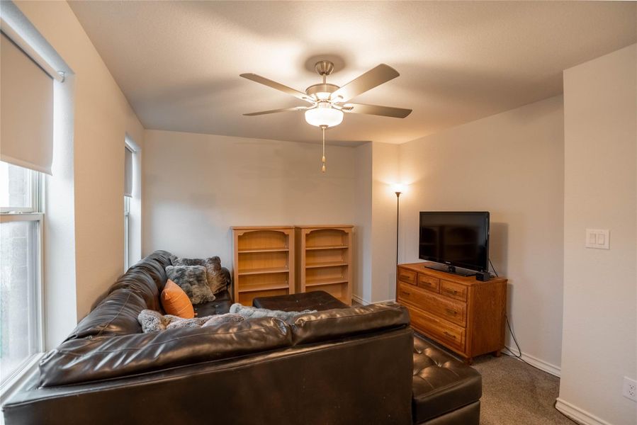 Carpeted living room featuring a ceiling fan and baseboards Carpeted living room featuring a ceiling fan and baseboards