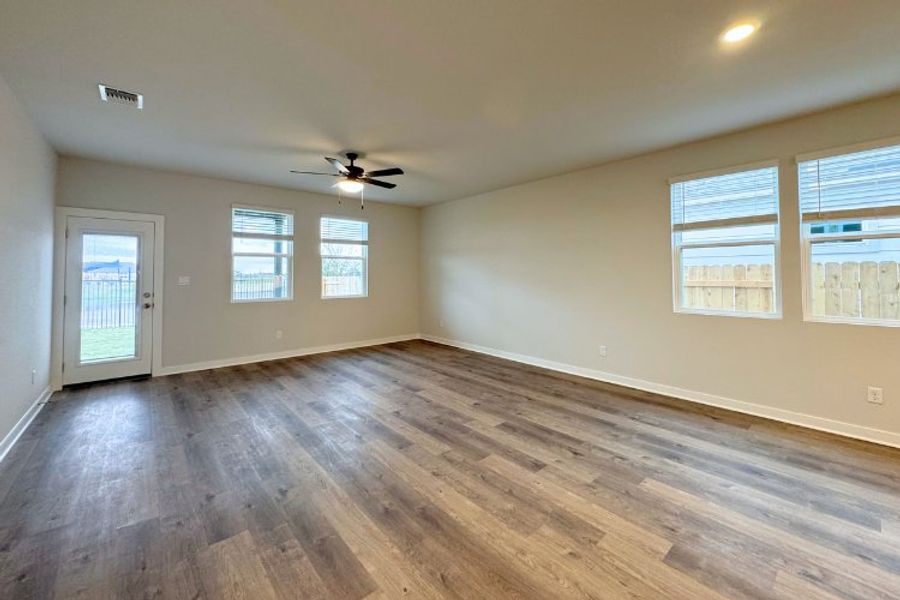 A room with a wood floor and a ceiling fan.