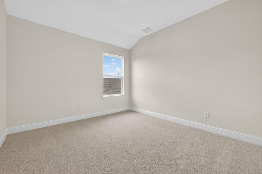 Spare room with light colored carpet and vaulted ceiling