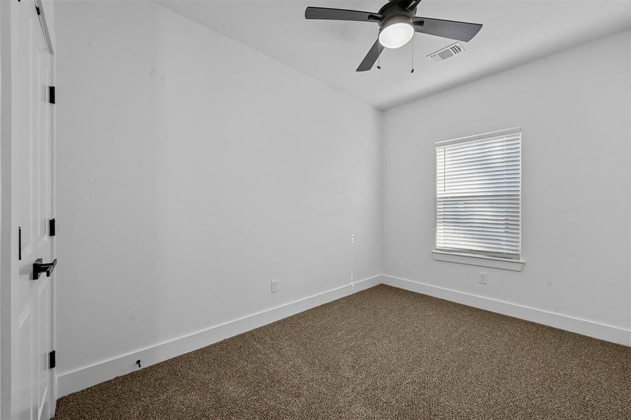 Carpeted spare room featuring ceiling fan