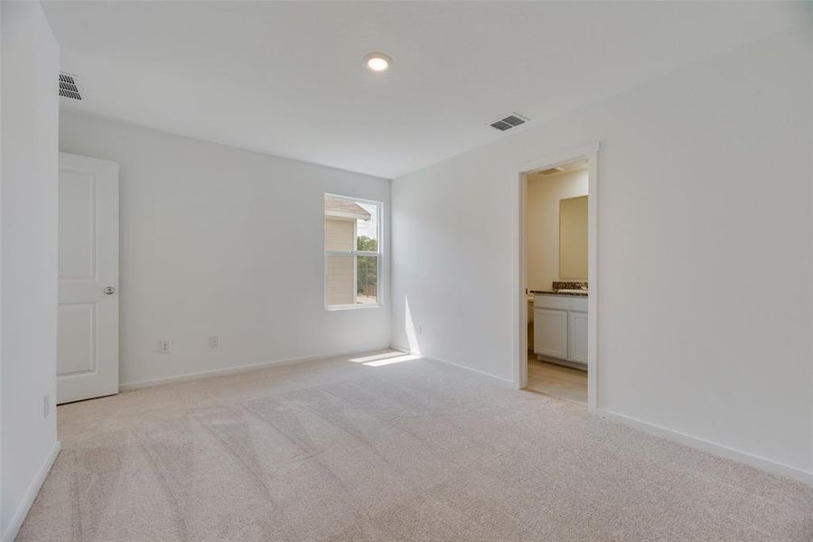 Unfurnished bedroom featuring light carpet and ensuite bath