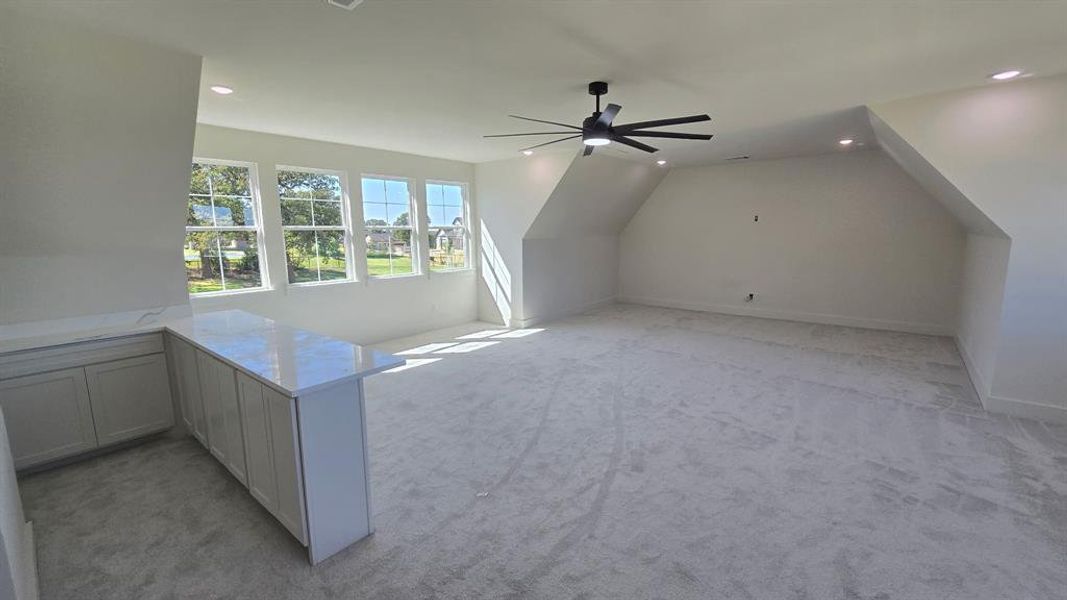Additional living space featuring light colored carpet, recessed lighting, ceiling fan, and lofted ceiling