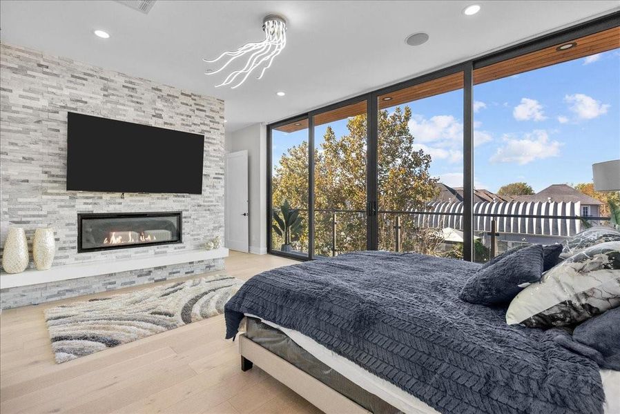 The primary bedroom offers its own private balcony, a stunning stone-accented fireplace, and unique designer lighting that creates a warm, luxurious ambiance. The primary bedroom offers its own private balcony, a stunning stone-accented fireplace, and unique designer lighting that creates a warm, luxurious ambiance.