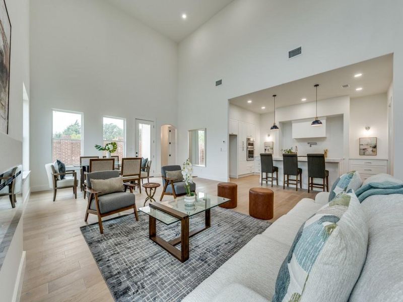 Living room featuring light hardwood / wood-style flooring and a high ceiling