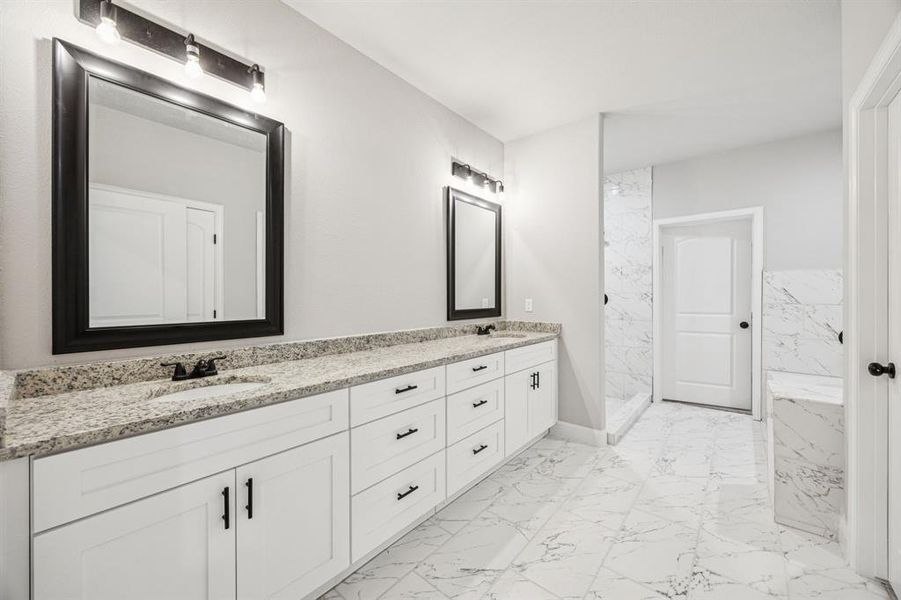 (Bedroom #1) Master Bathroom featuring light marble finish floors, double vanity, and a marble finish shower