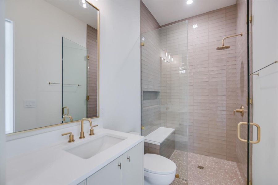 A well-appointed bathroom offers a large vanity, a spacious walk-in shower with a built-in bench, and stylish fixtures.