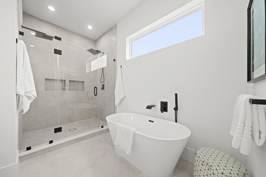 Relax after a long day in the freestanding soaking tub with waterfall faucet, a separate spray wand s and a transom window above allows for natural light to fill the bath. Relax after a long day in the freestanding soaking tub with waterfall faucet, a separate spray wand s and a transom window above allows for natural light to fill the bath.