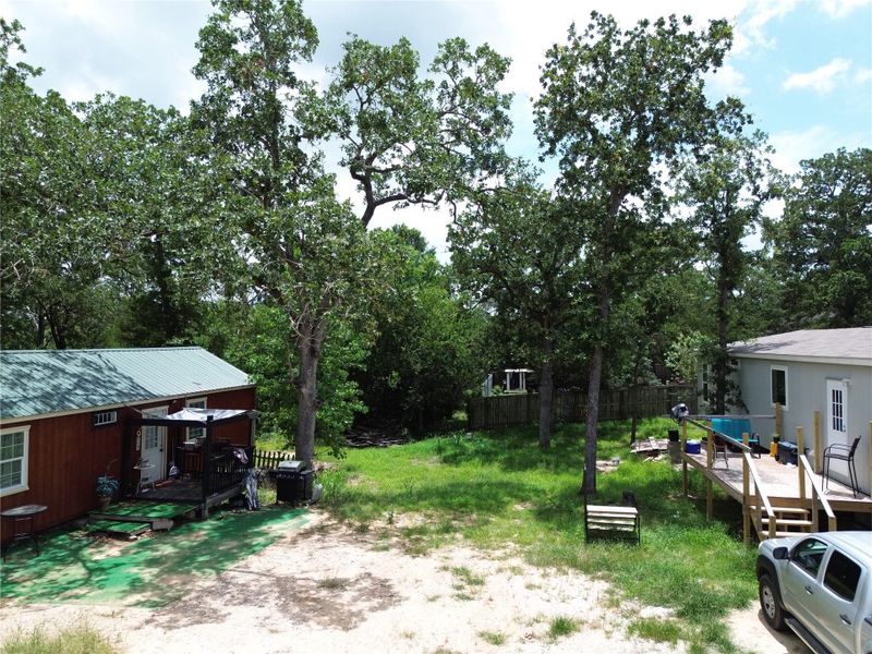 Mature trees provide a natural canopy over this serene outdoor space with a charming deck.