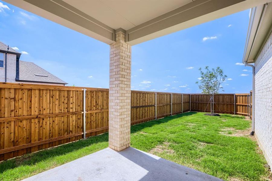 Covered patio featuring a brick support column and concrete flooring