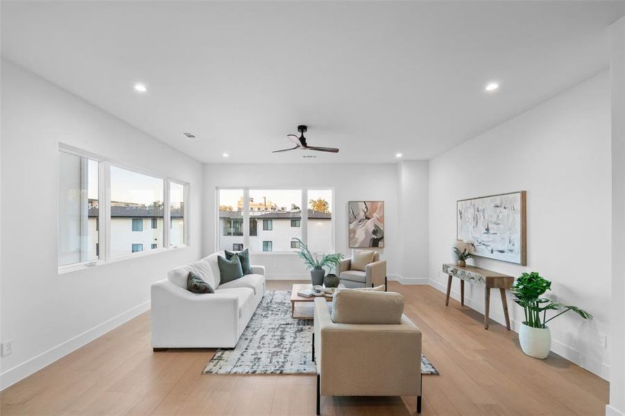 Living room featuring light wood-type flooring, recessed lighting, and a ceiling fan