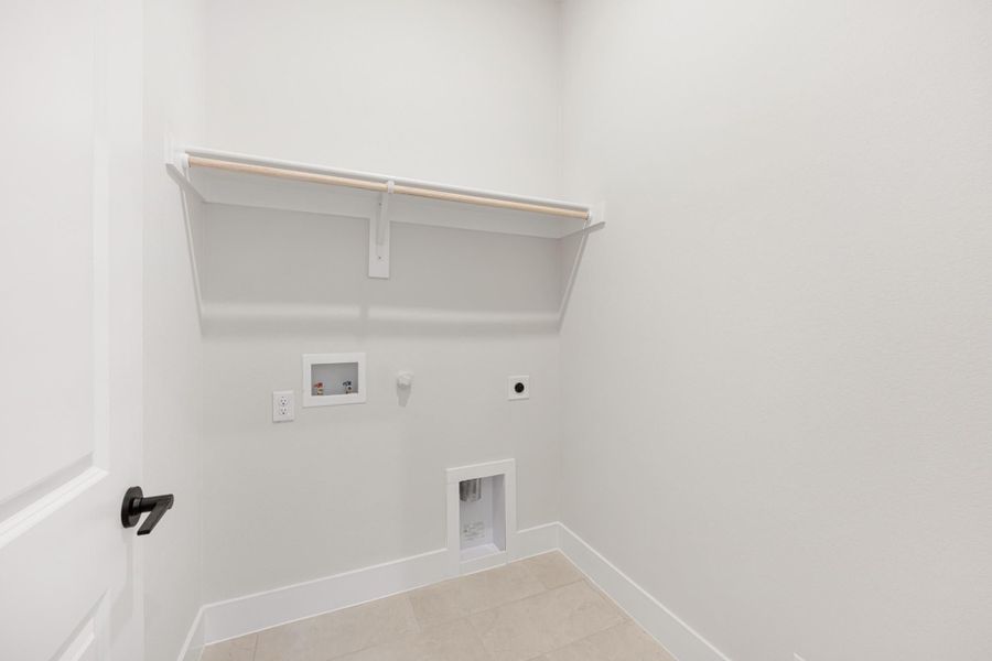 Laundry room with white walls, upper shelf, washer hookups, and gas dryer connection on tile floor