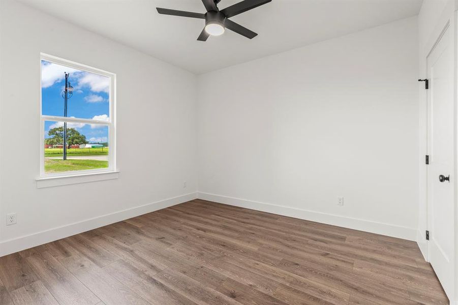 Empty room with a ceiling fan and wood finished floors