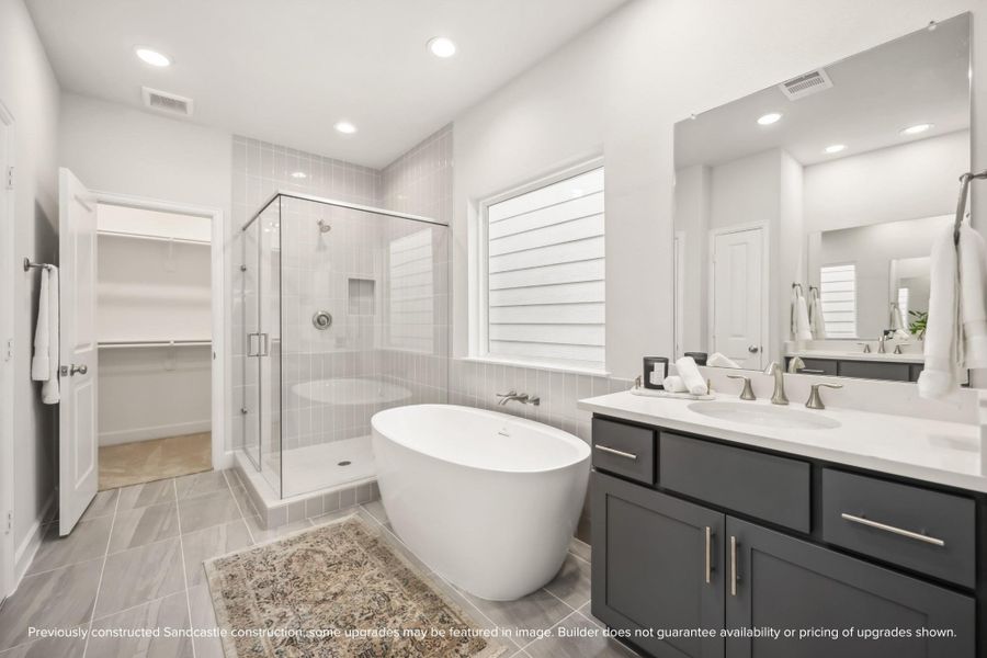 Indulge in a spa-like experience with a freestanding tub, step-in shower, dual sinks, a private water closet, and ample storage.