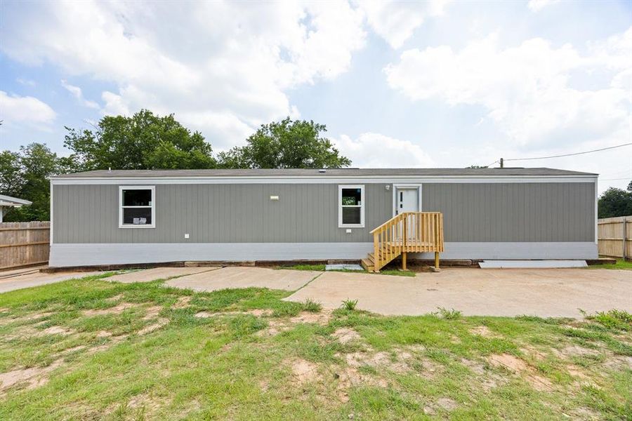 Grey siding exterior with a white front door and wooden porch stairs