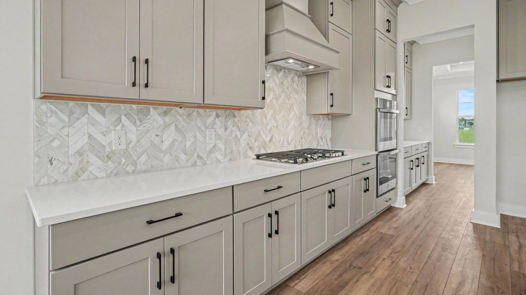 Kitchen with quartz countertops, pendant lighting, and tile backsplash