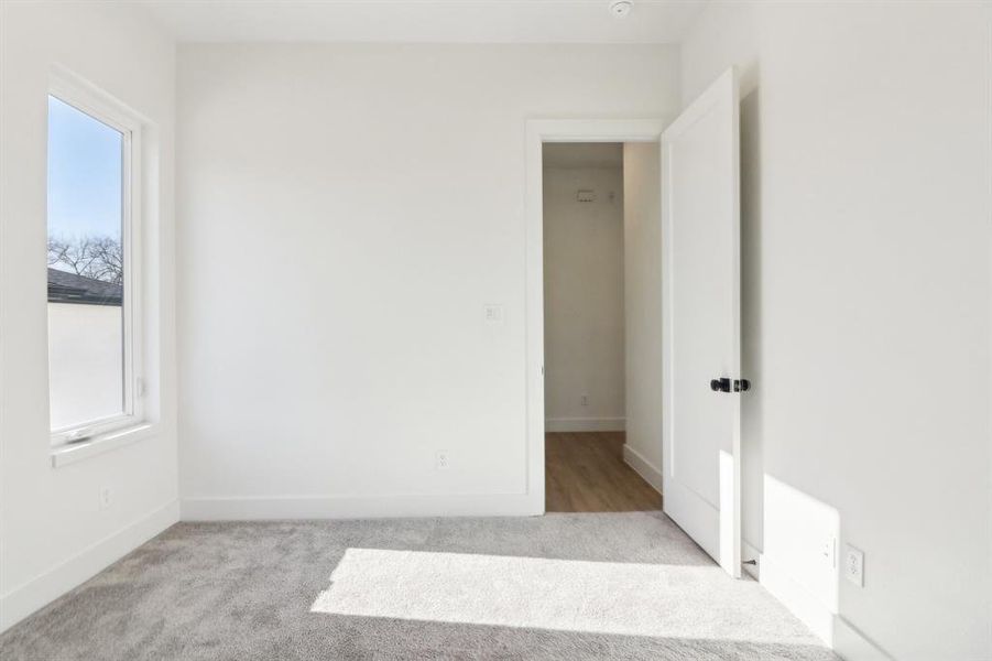 Empty room featuring light carpet