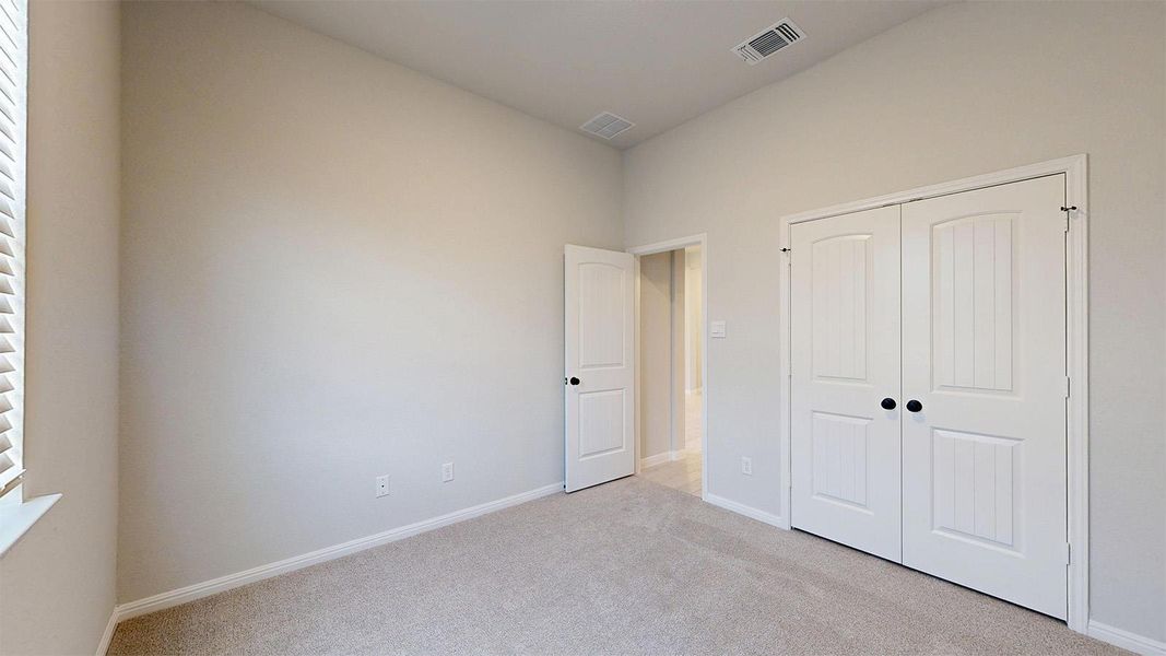 Unfurnished bedroom with light colored carpet and a closet Unfurnished bedroom with light colored carpet and a closet