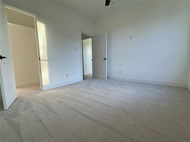 Unfurnished bedroom featuring light carpet and ceiling fan