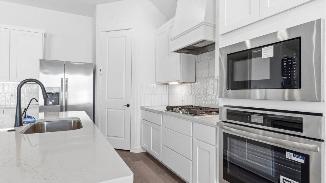 Bright and spacious kitchen with quartz countertops, stainless steel appliances, and an island with bar seating. Bright and spacious kitchen with quartz countertops, stainless steel appliances, and an island with bar seating.