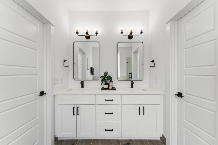 Indulge in everyday luxury in this elegant primary bathroom, where a freestanding soaking tub and a spacious walk-in shower offer the best of both worlds. The frameless glass shower enclosure showcases elegant tilework and dual showerheads, while the tub invites relaxation beneath a statement light fixture. A double vanity with quartz countertops and individual mirrors adds modern sophistication, and soft neutral tones create a serene, spa-like ambiance that elevates your daily routine. Indulge in everyday luxury in this elegant primary bathroom, where a freestanding soaking tub and a spacious walk-in shower offer the best of both worlds. The frameless glass shower enclosure showcases elegant tilework and dual showerheads, while the tub invites relaxation beneath a statement light fixture. A double vanity with quartz countertops and individual mirrors adds modern sophistication, and soft neutral tones create a serene, spa-like ambiance that elevates your daily routine.