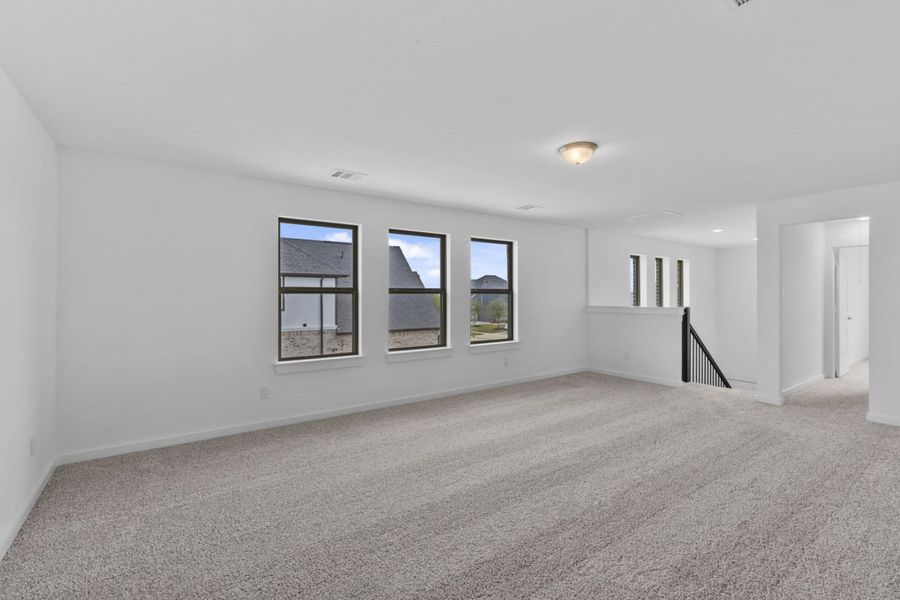 Image of a gameroom with tan carpeting, white walls and windows with brown trim Image of a gameroom with tan carpeting, white walls and windows with brown trim
