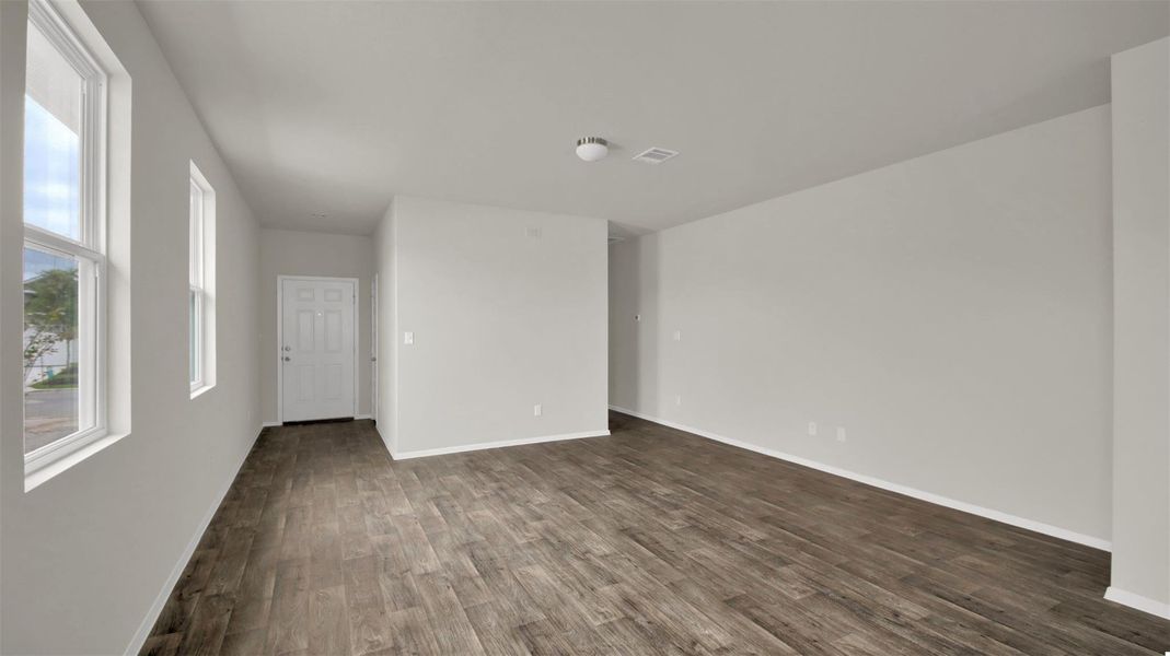 Unfurnished room featuring dark wood-style floors and baseboards