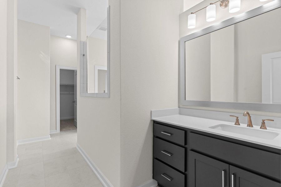 Beautifully designed primary bath featuring his and her private vanities, framed mirrors, and elegant finishes—an inviting space to begin and end your day.