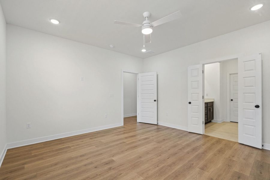 Spacious room with wood-finish flooring and white baseboards