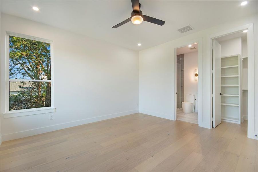 Unfurnished bedroom with a spacious closet, light wood-type flooring, recessed lighting, and a ceiling fan Unfurnished bedroom with a spacious closet, light wood-type flooring, recessed lighting, and a ceiling fan