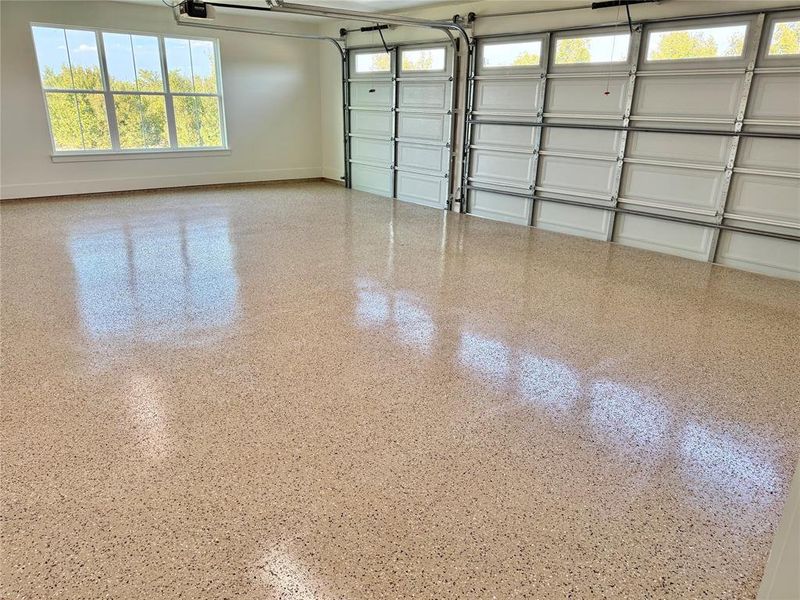 Garage featuring baseboards and a garage door opener Garage featuring baseboards and a garage door opener