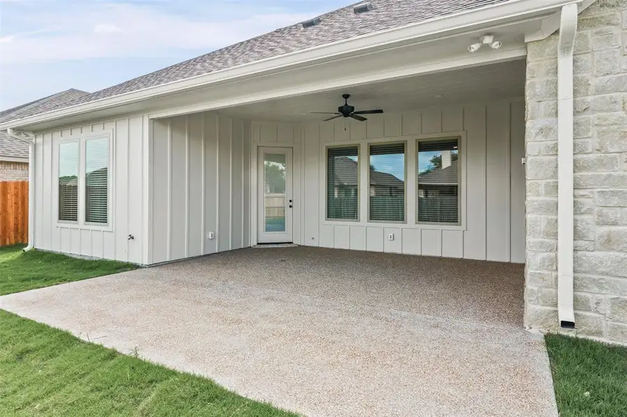 The property features a covered patio with an exposed aggregate concrete surface and a ceiling fan