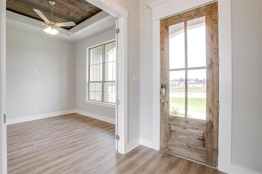 Foyer featuring a wealth of natural light, ceiling fan, light wood-type flooring, and wooden ceiling