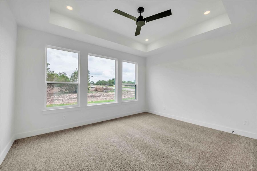 Empty room featuring carpet floors, recessed lighting, a tray ceiling, and baseboards Empty room featuring carpet floors, recessed lighting, a tray ceiling, and baseboards